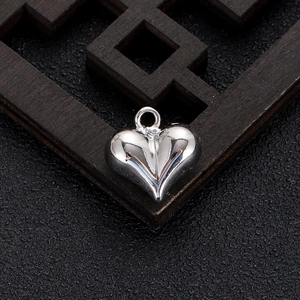 Detailed view of a polished heart-shaped silver pendant with a closed ring connector