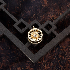 Macro shot of gold plated car wheel charm with inlaid zircons for DIY jewelry making
