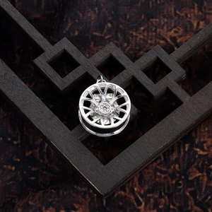 Macro view of a 14K copper car wheel pendant featuring red brake calipers and tiny stones