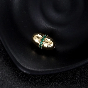 Vue macro du pendentif Mauvais Œil plaqué or 14K avec zircon vert et texture nervurée