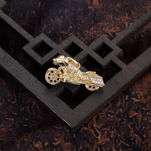 Detailed close-up of golden cruiser motorcycle pendant with sparkling white rhinestones
