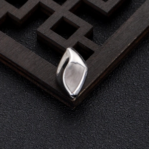 Macro shot of polished silver irregular waterdrop beads on a dark wooden background