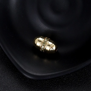 Détail macro d'une perle barillet plaquée or avec zircon jaune et texture nervurée pour bijoux