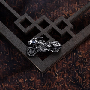 Macro shot of punk style motorcycle pendant with white rhinestones on dark metal base