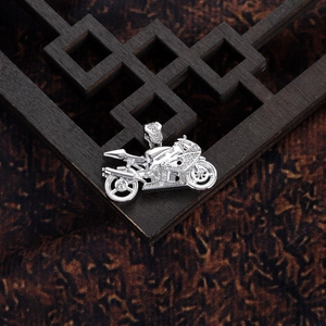 Macro shot of silver motorcycle pendant with inlaid zircons and micro-carved engine details