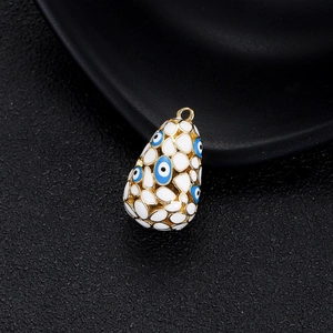 Vue détaillée du pendentif Evil Eye doré 14K avec émail blanc et zircons bleus brillants