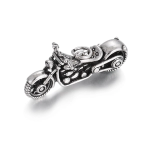 Detailed vintage silver motorcycle charm showing intricate engine parts and wheels