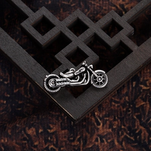 Detailed view of motorcycle pendant with white rhinestones on dark wooden background