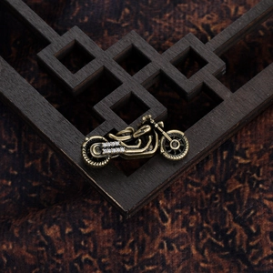 Macro shot of retro motorcycle pendant with white crystals on a wooden base