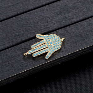 Detailopname van een Hamsa-handconnector van goud metaal met blauwe turkoois kralen inleg
