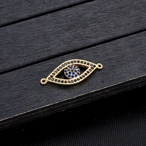 Detailweergave van de gouden evil eye connector met blauwe en zwarte kristallen