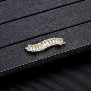 Macro-opname van de goudkleurige armbandschakel met zirkonia en turquoise kralen