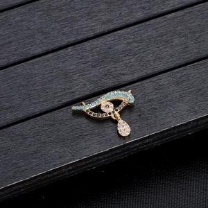 Macro-opname van evil eye hanger met blauwe kralen en kristallen druppel in goud