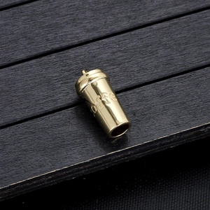 Macro-detail van een gouden koffiekop-hanger met gravure op een donkere houten achtergrond