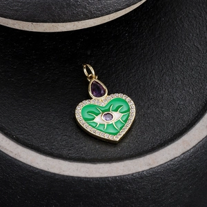 Dettaglio del ciondolo a cuore con smalto verde, malocchio e gemma preziosa viola