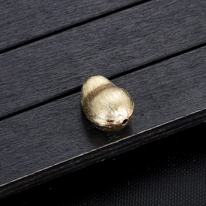 Detailopname van een gouden pinda-hanger met geborstelde textuur voor DIY-sieraden