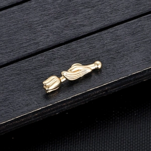 Detailopname van de gouden tulp hanger met gepolijste afwerking op donker hout
