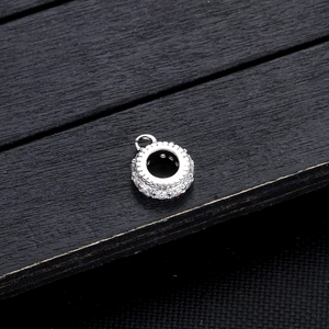 Detail van een zilveren bedelhanger bezet met fonkelende micro-geplaveide zirkonia