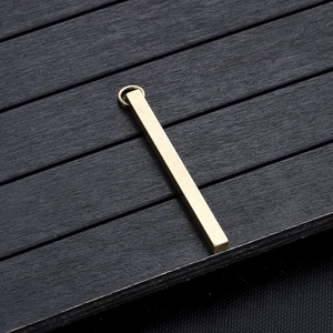Macro-opname van een rechthoekige messing hanger in mat goud met vintage textuur