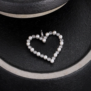 Dettaglio del ciondolo a cuore in argento con perle bianche e zirconi cubici scintillanti