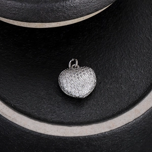 Macro di un ciondolo a cuore in argento con cristalli su pietra nera testurizzata