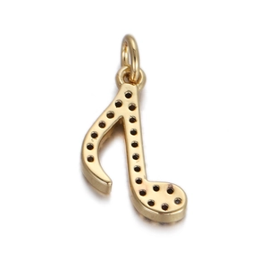 Macro shot of a golden music note charm with detailed pave settings for jewelry making