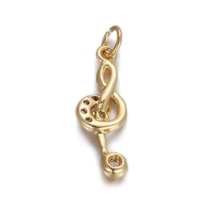 Detailed view of a gold musical treble clef pendant with sparkling cubic zirconia stones