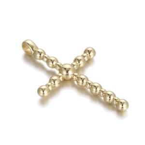 Macro shot of gold-plated beaded cross pendant charm with polished metallic finish