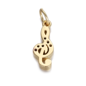 Close-up of polished gold treble clef music note pendant charm for DIY jewelry