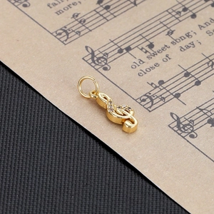 Detailed view of a gold musical note pendant with sparkling zircon inlays on music sheet