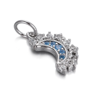 Macro shot of silver crescent moon pendant with blue diamonds and white cubic zirconia
