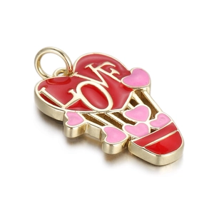 Macro shot of a red and pink hot air balloon heart pendant with LOVE text and gold details