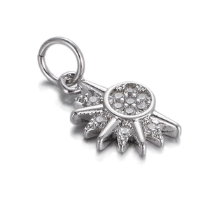 Detailed view of silver sunburst charm pendant with sparkling crystals on white background