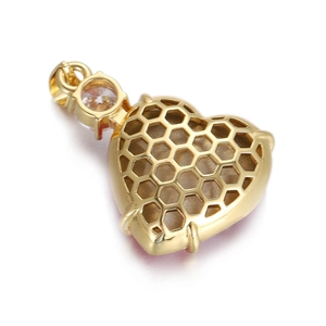 Vue macro du pendentif en cœur doré avec motif alvéolé et cristal de zircone rond