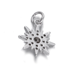 Close-up of a polished silver star pendant with symmetrical stone settings and link ring