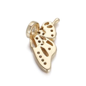 Detailed view of a gold butterfly charm with sparkling zircon inlay and hollow design