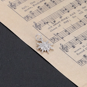 Detailed view of silver octagonal star pendant with pavé cubic zirconia on musical score