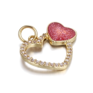 Detail of a heart-shaped pendant featuring gold plating with pink glitter and micro-pave stones