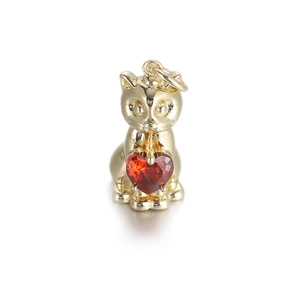 Macro view of golden cat charm holding a red heart zircon for DIY jewelry making