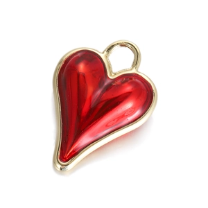 Detailed close-up of a golden heart pendant with vibrant red enamel and integrated loop
