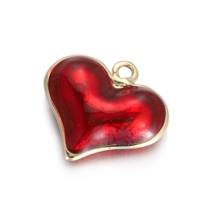 Detailed view of heart-shaped red enamel pendant with gold-plated metal edges on white background