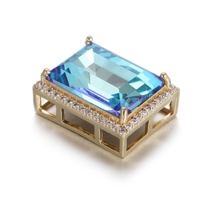 Gros plan d'un pendentif en cristal bleu avec placage d'or et halo de zircones cubiques