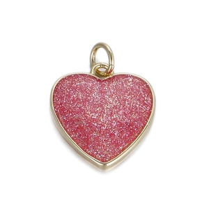 Dettaglio del ciondolo a cuore con glitter rosa con bordo in oro e anello superiore