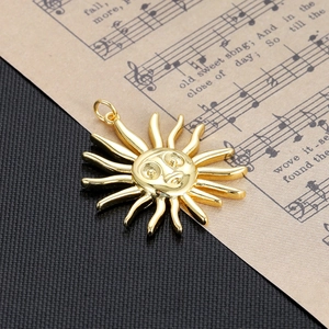 Macro detail of a vintage gold sun face charm on an artistic sheet music background