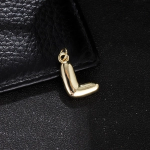 Close-up of golden balloon-style letter L pendant with a polished mirror finish