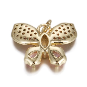 Detailed view of butterfly charm with gold plating and pink zircon gemstones
