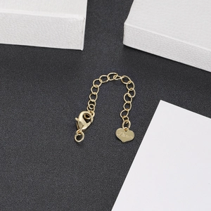 Macro shot of a gold heart pendant with 'Love' engraving and lobster clasp chain