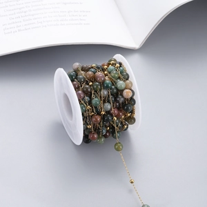 Close-up of colorful natural stone beaded chain on a spool for DIY jewelry