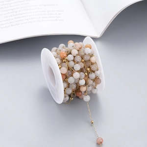 Detail of colorful natural stone beads on a golden stainless steel DIY craft chain