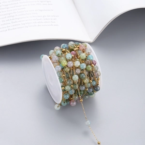 Macro detail of colorful natural stone beads on a gold stainless steel chain roll